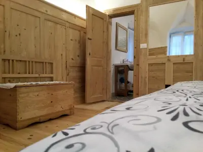 a bedroom with a bed and wooden walls at Da Valentina in Castelfondo