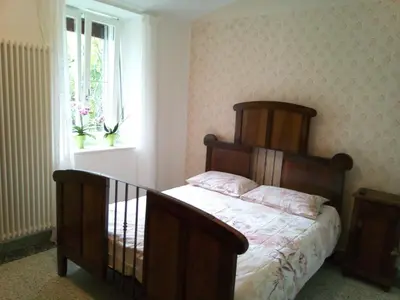 a bedroom with a wooden bed and a window at Da Valentina in Castelfondo