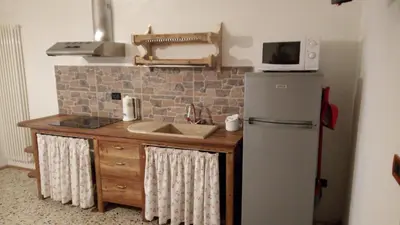 a kitchen with a refrigerator and a microwave on the wall at Da Valentina in Castelfondo
