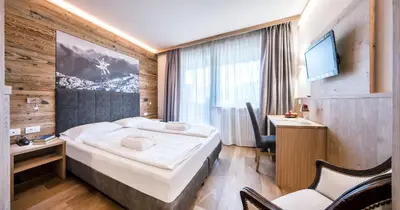 a hotel room with a bed and a television at Parc Hotel Miramonti in Fiè