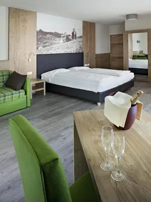 a bedroom with a bed and a table with wine glasses at Parc Hotel Miramonti in Fiè