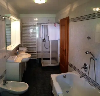 a bathroom with two sinks and a tub and a shower at Casa Guido e Laura in Pozza di Fassa