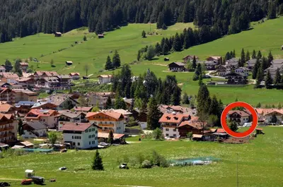 a red circle in a village in a field at Casa Guido e Laura in Pozza di Fassa