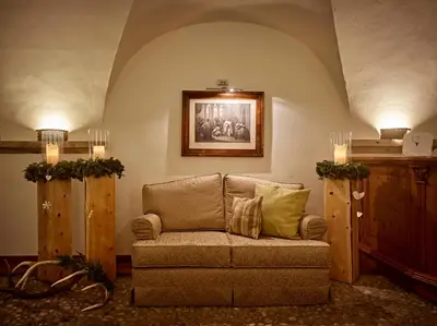 a living room with a couch and a picture on the wall at Romantic Hotel Excelsior in Cavalese