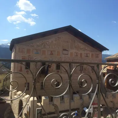 a building with a fence in front of it at Romantic Hotel Excelsior in Cavalese