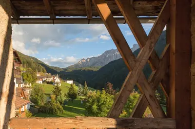 a view from a window of a village in the mountains at Romantik Hotel Post in Nova Levante