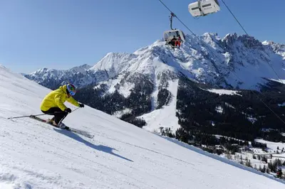 a person is skiing down a snow covered mountain at Romantik Hotel Post in Nova Levante