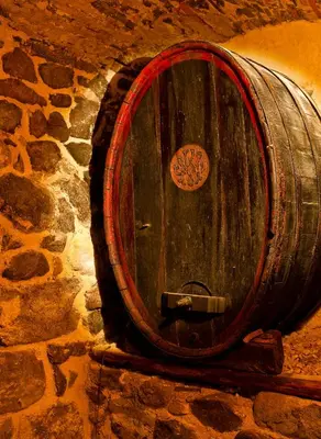 a wooden barrel sitting on top of a stone wall at Hotel Elefant in Ora/Auer