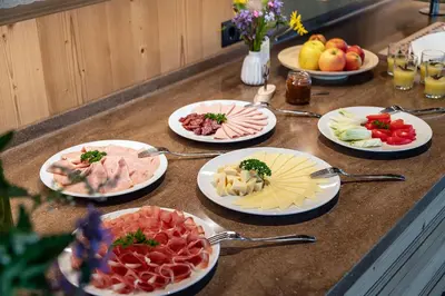a buffet with plates of food on a counter at Moarlhof - Farm Nature Resort in Castelrotto