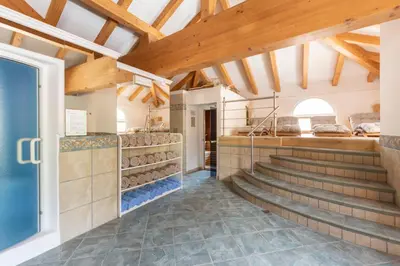 a room with stairs in a building with wooden ceilings at Hotel Faloria in Moena