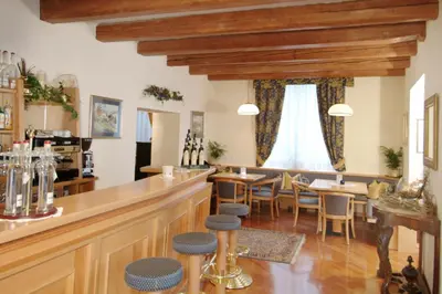 a restaurant with a bar and tables and chairs at Hotel Faloria in Moena
