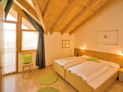 a bedroom with a large bed and a large window at Appartements Erika in Falzes