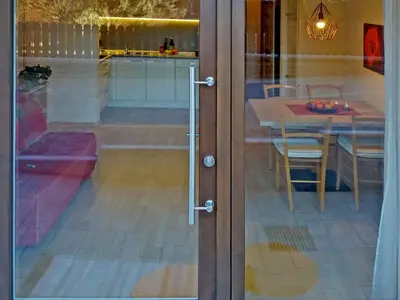 a glass door to a dining room with a table at Appartements Erika in Falzes