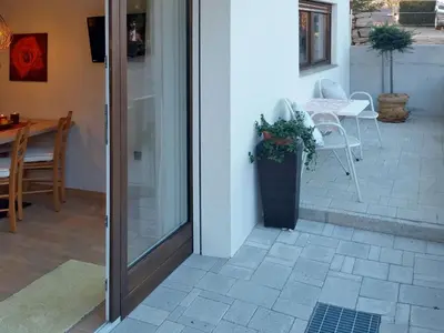 a door to a patio with a table and chairs at Appartements Erika in Falzes