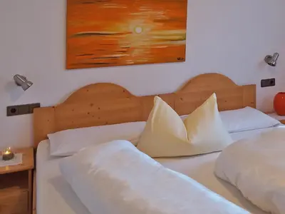 two beds in a bedroom with a painting on the wall at Appartements Erika in Falzes
