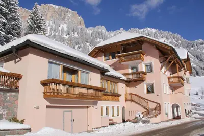 a house in the mountains with snow on the ground at Garni Criss in Colfosco