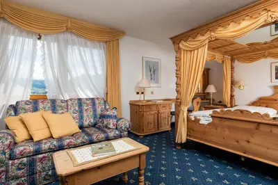 a living room with a couch and a bed at Garni Criss in Colfosco