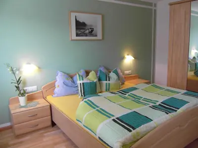 a bedroom with a bed with a green wall at Thalerhof in Prenn