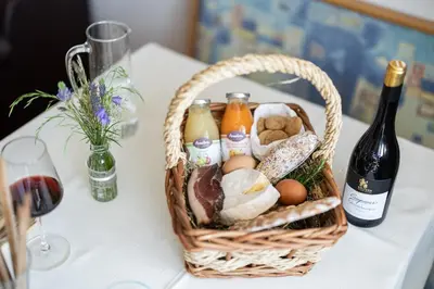 a basket of eggs and bottles of wine on a table at EGGER Apartments & Suites in Villandro