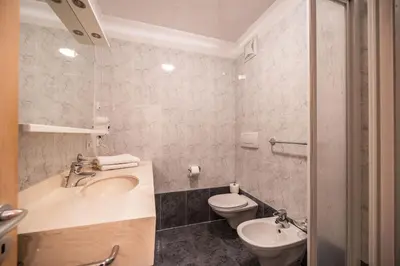 a bathroom with a sink and a toilet at EGGER Apartments & Suites in Villandro