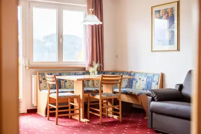 a living room with a table and chairs and a couch at EGGER Apartments & Suites in Villandro