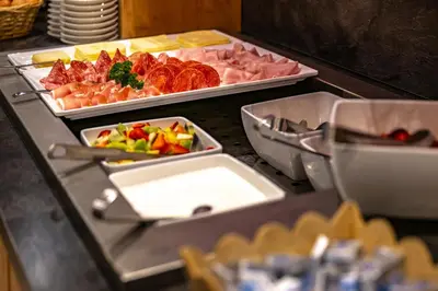 a buffet with three trays of food on a table at Hotel Schmiedhof in Maranza