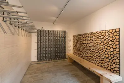 a room with a wall of firewood at Hotel Schmiedhof in Maranza