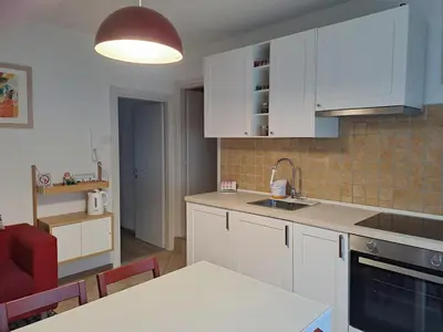 a kitchen with white cabinets and a table and chairs at Casa Vanna in Mezzano