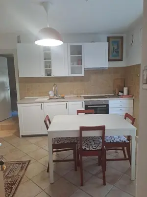 a kitchen with white cabinets and a table and chairs at Casa Vanna in Mezzano