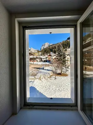 a window in a room with a view of a resort at Central Apartment Canazei in Canazei