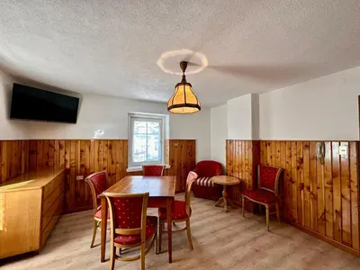 a dining room with a table and chairs and a television at Central Apartment Canazei in Canazei