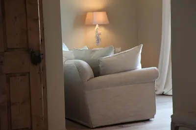 a living room with a chair and a lamp at Hotel Alle Ciaspole in Fondo