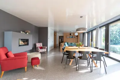 a dining room and living room with a table and chairs at Villa Baronessa in Caldaro