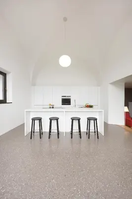 a kitchen with three stools and a white counter at Villa Baronessa in Caldaro