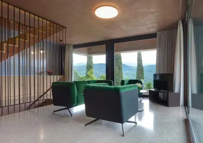a living room with green chairs and a television at Villa Baronessa in Caldaro