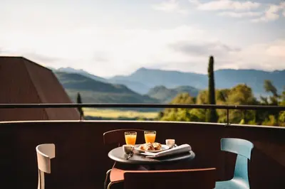 a table with two glasses of orange juice on a balcony at Villa Baronessa in Caldaro