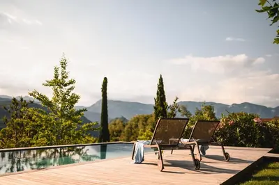 a couple of chairs sitting next to a swimming pool at Villa Baronessa in Caldaro