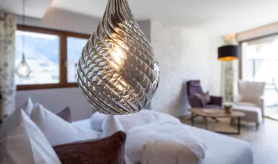 a large silver vase sitting on top of a bed at Hotel Sonnbichl in Tirolo