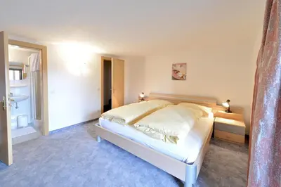 a bedroom with a large bed and a bathroom at Gasthof Ebner Pfiffikus in Aldino