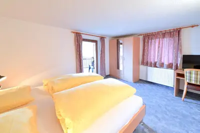 a hotel room with two beds and a television at Gasthof Ebner Pfiffikus in Aldino