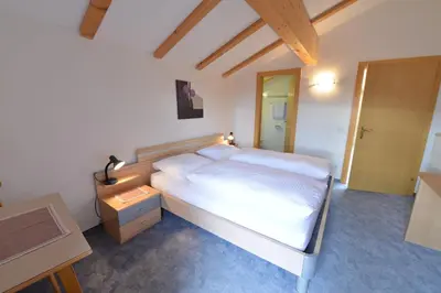 a bedroom with a large white bed and a desk at Gasthof Ebner Pfiffikus in Aldino