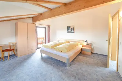 a bedroom with a bed and a desk and a window at Gasthof Ebner Pfiffikus in Aldino