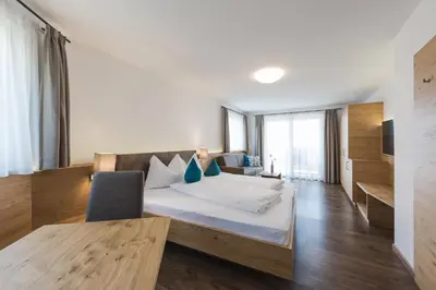 a hotel room with a bed and a television at Apparthotel Zunneler in Schenna