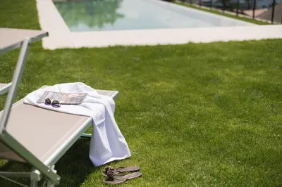a table with a napkin on top of it on the grass at Apparthotel Zunneler in Schenna
