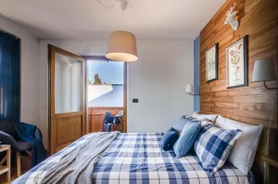 a loft bed in a room with wooden stairs at Villa Recla in Ronzone