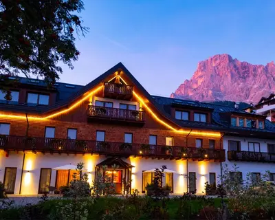 a large building with snow on the ground at Residence Langes in San Martino di Castrozza