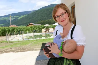 a woman holding a baby in her arms at Lerchnhof in Valdaora