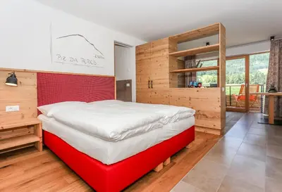 a large bed in a room with wooden walls at Lerchnhof in Valdaora
