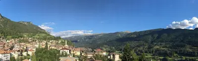 a town on a hill with mountains in the background at Apartments Trettel in Tesero
