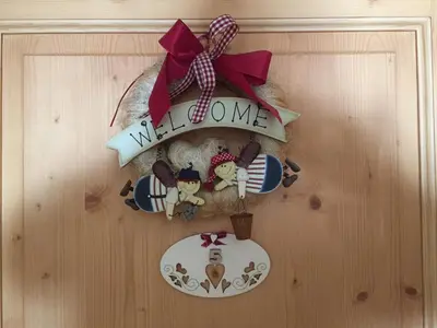 a wreath on a door with a welcome sign at Apartments Trettel in Tesero